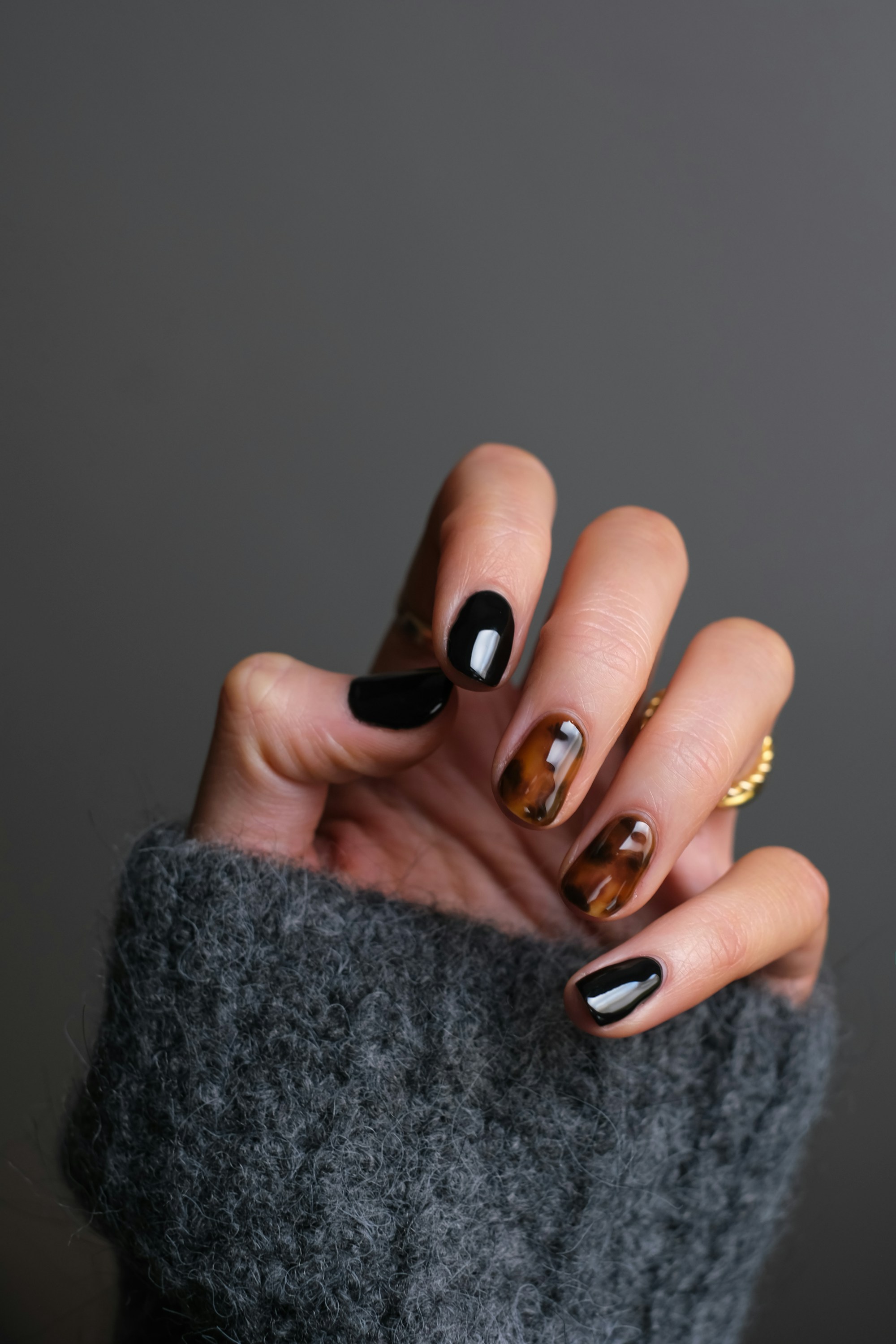 Glossy tortoiseshell and black nail design — editorial inspiration