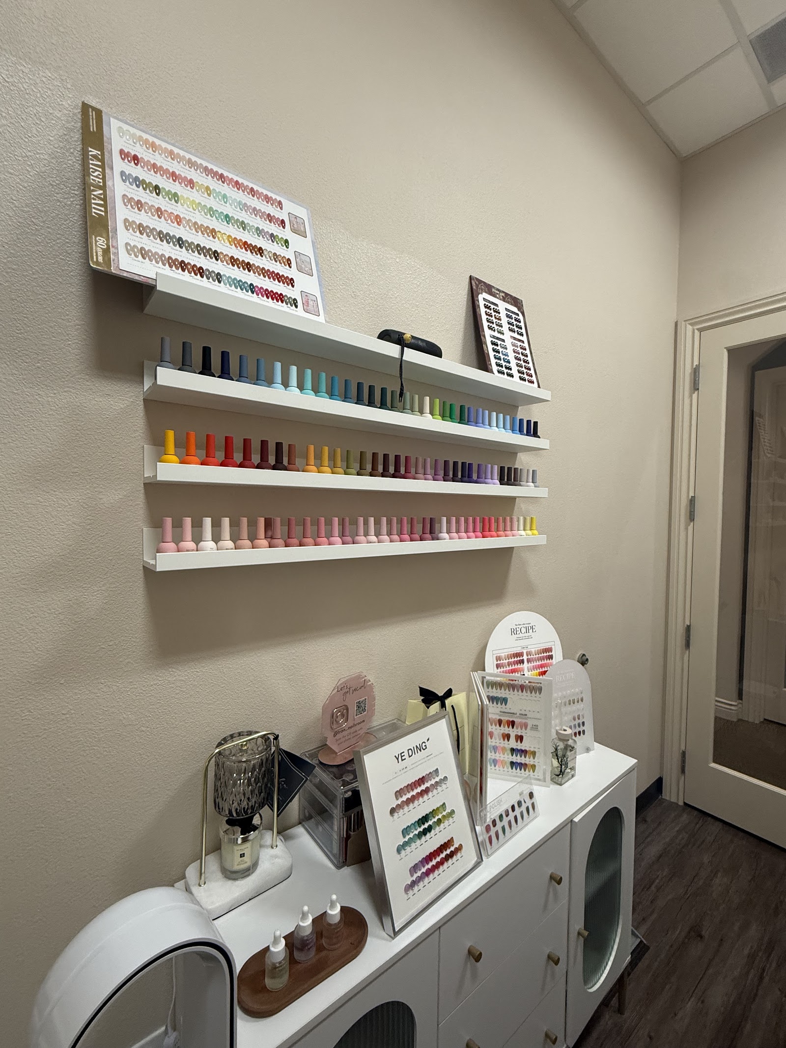 The real Âme Libre private suite with shelves of gel colors and manicure swatches